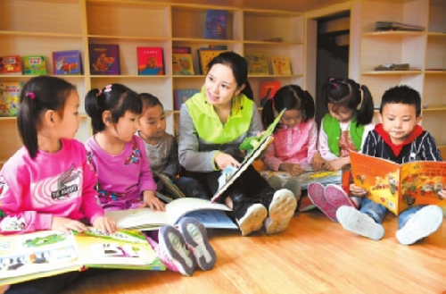 兰州实验幼儿园新区分园的老师在阅览室带领孩